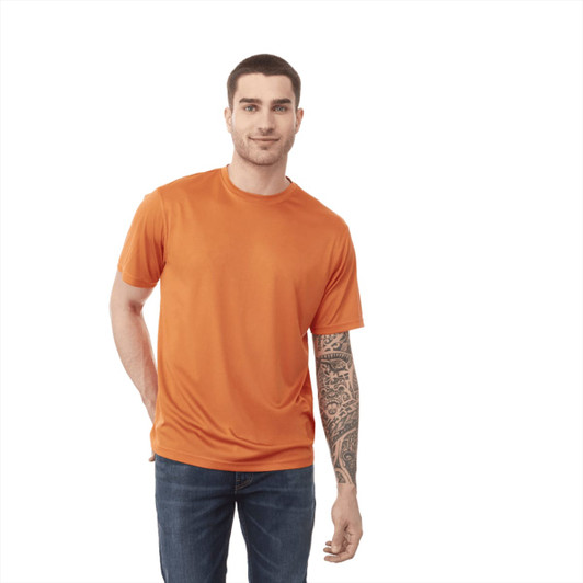 An orange short sleeve tech tee for men, featuring a logo, paired with blue jeans.