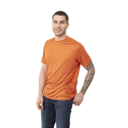 A short sleeve tech tee for men in bright orange, featuring a logo. The model is smiling and wearing jeans.