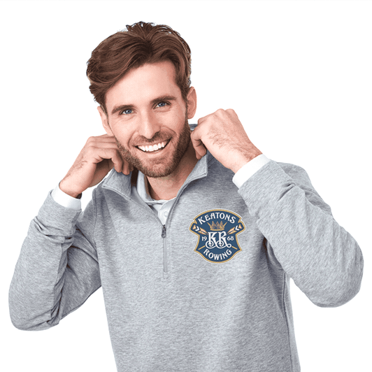 A light grey quarter zip jacket for men with a logo on the chest. The model smiles while adjusting the collar.