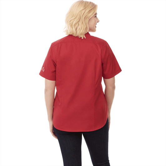 A women's short sleeve button-up shirt in red, featuring a logo on the sleeve.