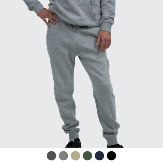 A person wearing grey unisex sweatpants with a relaxed fit, featuring an elastic waistband and cuffed ankles.