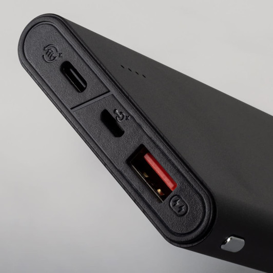A black power bank with USB-C and USB-A ports, featuring a minimalist design and a small logo.