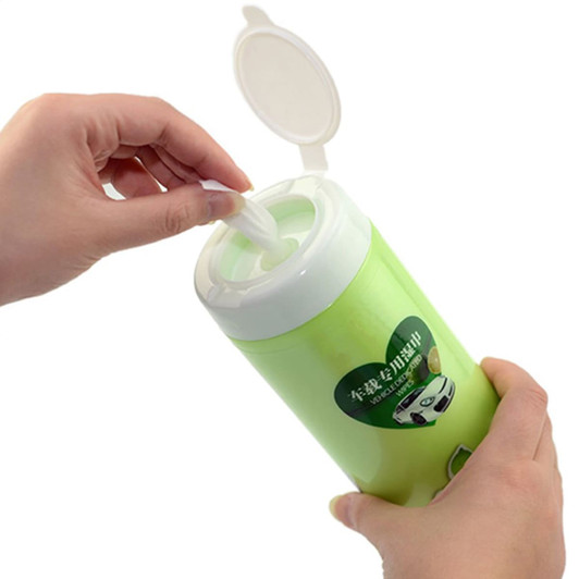 A green container of wet tissues held in hand, designed for cleaning, with a lid and branding.