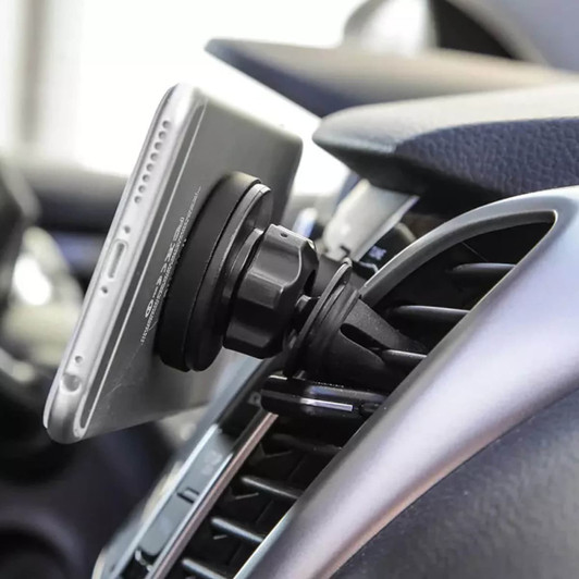A car phone holder in black attaches to a vehicle's air vent holding a smartphone securely in place.