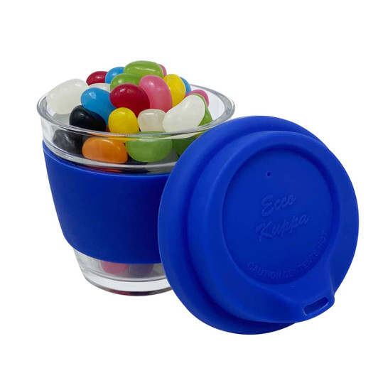 A glass coffee cup with a blue silicone lid, filled with colourful jelly beans. It features a branding logo.