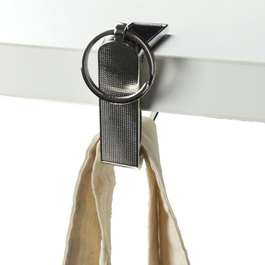 A metal mobile stand and hanger key ring, featuring a shiny silver finish, holding a fabric strap.