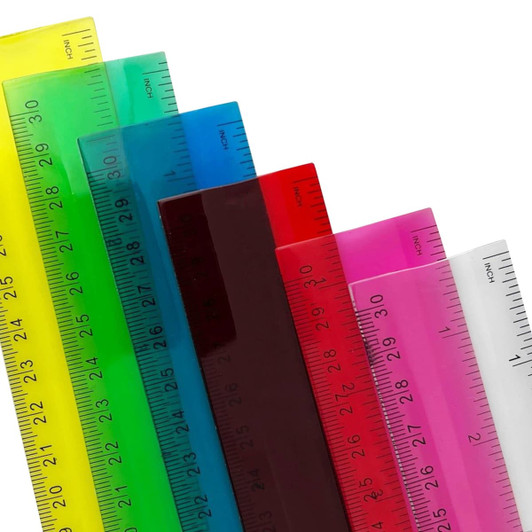 A selection of PVC soft plastic rulers in various vibrant colours, each marked with inch measurements and a logo.
