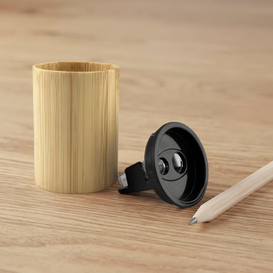 A bamboo pencil sharpener in a cylindrical shape, with a black sharpening mechanism and a light-coloured wooden pencil beside it.