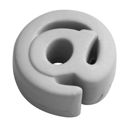 A grey stress relief shape in the form of an "@" symbol. It has a smooth texture and a minimalist design.