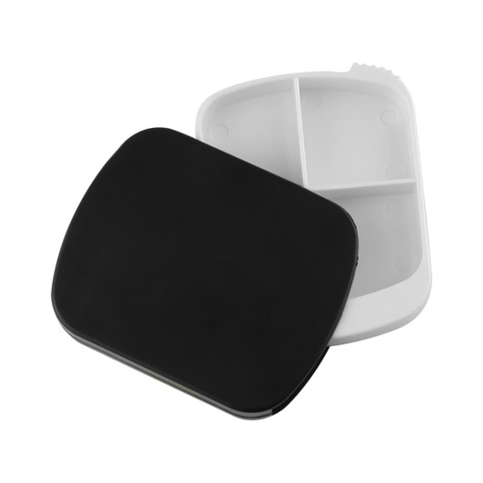 A black spin pill box with a white interior, featuring compartments for organising medication. It has a logo on the exterior.