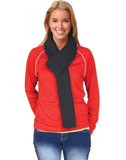 A woman wearing a dark grey cable knit scarf with a ribbed pattern, paired with a red top and jeans.