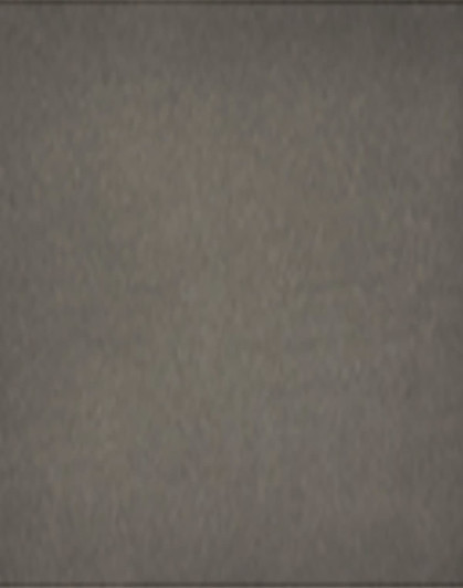 A grey removable knee pad with a branded logo. The surface appears textured and durable for various applications.