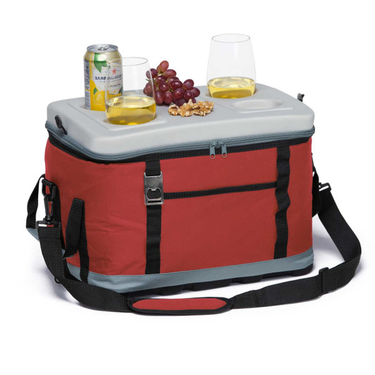 A red cooler with a grey lid, featuring drinks, glasses, grapes, and nuts on top, plus a carry strap.