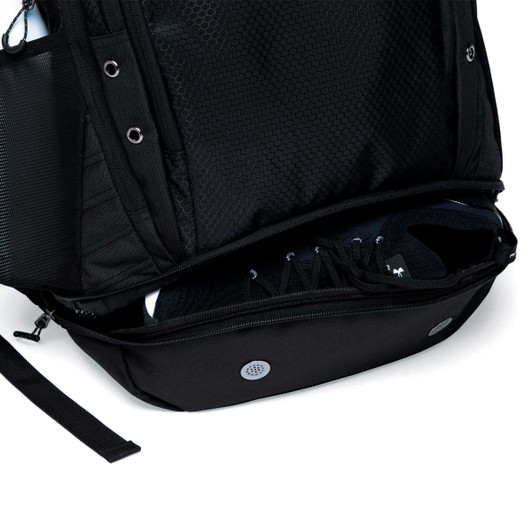 A black backpack with a mesh exterior and a zipped compartment for shoes at the bottom.