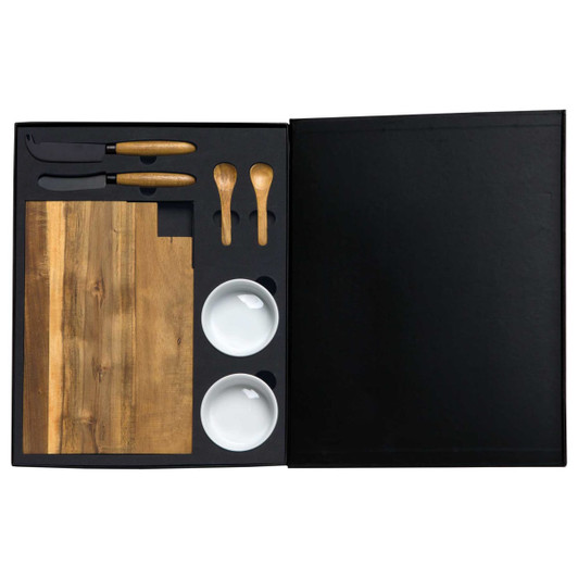 A gourmet cheese board set featuring a wooden board, knives, spoons, and two white bowls, all packaged in a black box.