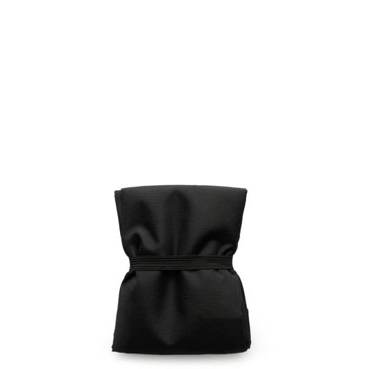 A reusable grocery bag in black, compactly folded with an elastic band securing it.