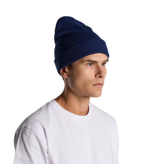 A navy cuff beanie worn by a person, featuring a ribbed texture and a logo.
