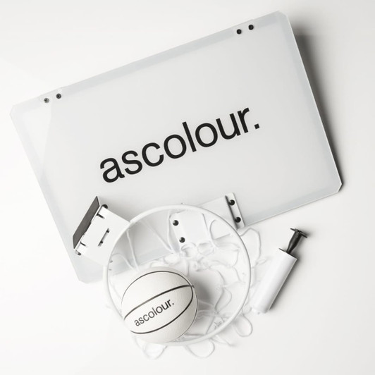 A mini basketball set featuring a white backboard, a basketball, a pump, and hardware for mounting, all with branding.