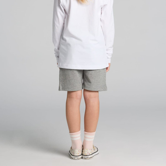Kids stadium shorts in grey, featuring a simple design. Worn with a long-sleeve white top and patterned socks.