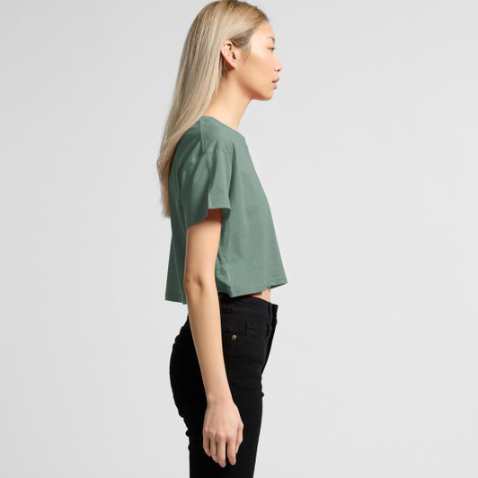 A cropped green t-shirt viewed from the side, featuring a simple design and a light fabric.