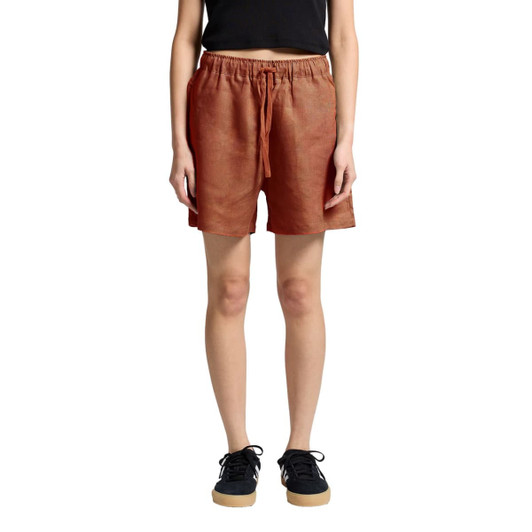 Linen dress shorts in a terracotta colour featuring an elastic waistband and side pockets, shown on a model.