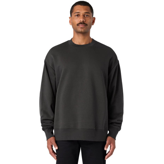 A dark grey jumper featuring a crew neck and long sleeves, presented on a male model. The garment has a branding logo.