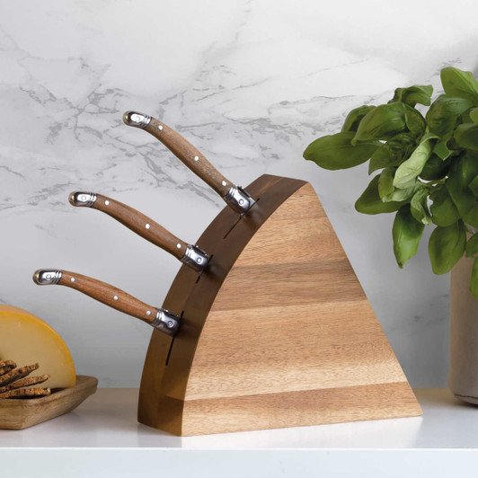 A wedge-shaped wooden cheese knife block set with three knives, featuring stainless steel blades and wooden handles.