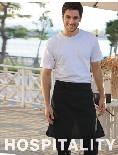 A man wearing a black cotton drill half apron, smiling outdoors near a waterfront setting. The apron has no pockets.