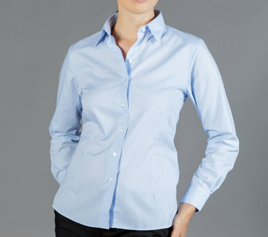 A light blue button-up shirt with a check pattern, featuring a collar and a fitted design. The model has one hand on her hip.