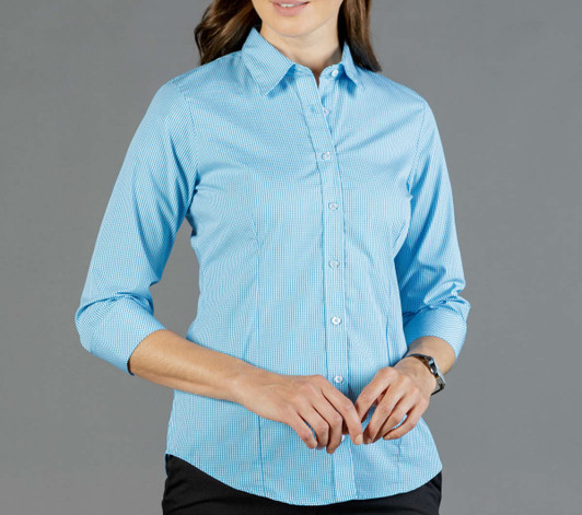 A button-up shirt in light blue gingham with long sleeves and a fitted design. The shirt has a logo on it.