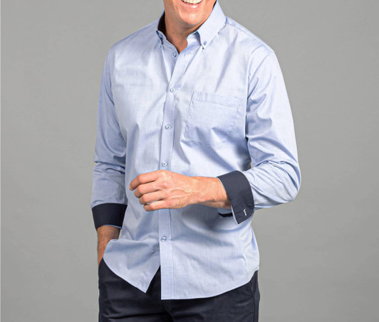 A button-up shirt in light blue with dark blue cuffs and a chest pocket, featuring a subtle logo.