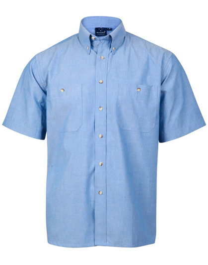A short-sleeve button-up shirt in light blue chambray with two front pockets and a collar, featuring a logo.