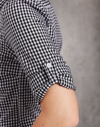 A black and white gingham check roll-up long-sleeve shirt featuring button details on the sleeves and a logo.