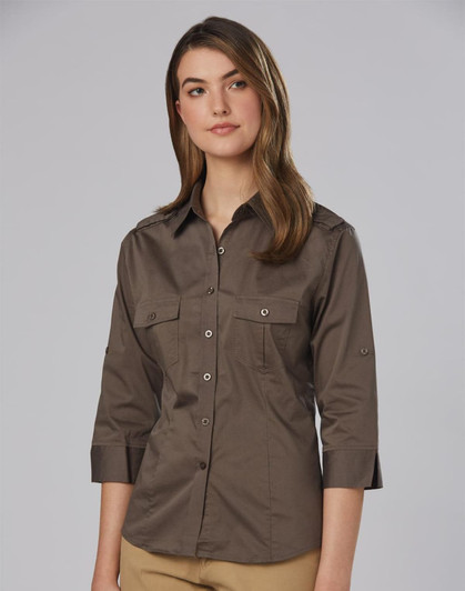 A women's military-style shirt in khaki with 3/4 sleeves and two front pockets, featuring a logo on the fabric.