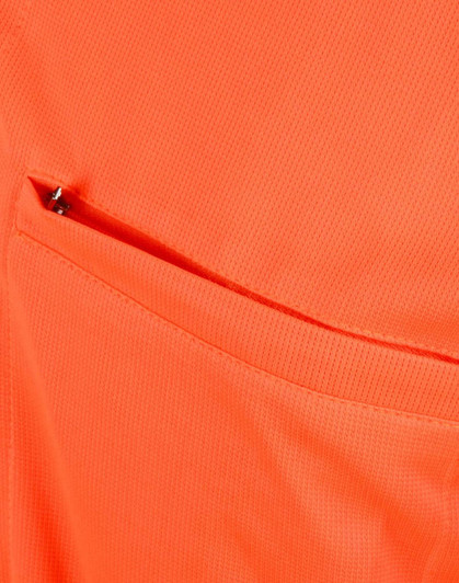 An orange polo shirt featuring a vented pocket, showcasing a breathable fabric texture.