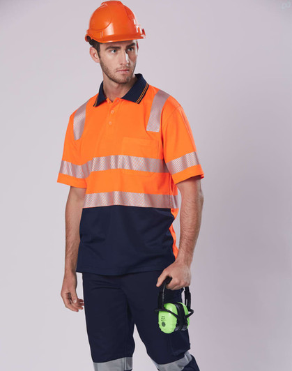 An orange and navy safety polo shirt with reflective strips, worn with a hard hat and holding ear protection.
