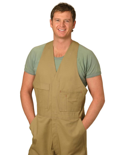Men's cotton drill action back overall in beige, featuring pockets and worn over a green shirt. Model is smiling.