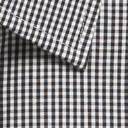 A close-up of a button-up shirt featuring a black and white gingham pattern with a collar detail.