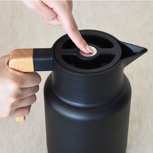 A drink bottle in black with a wooden handle and a sleek design, featuring a push button lid.