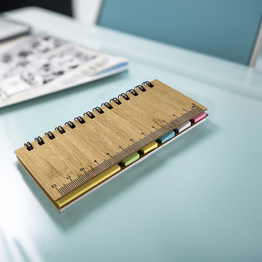 A bamboo sticky note pad with a wooden cover and a ruler, featuring multiple coloured sticky notes.