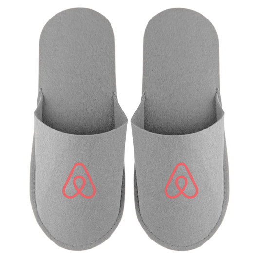 A pair of grey felt slippers featuring a logo, designed for comfort and casual wear.