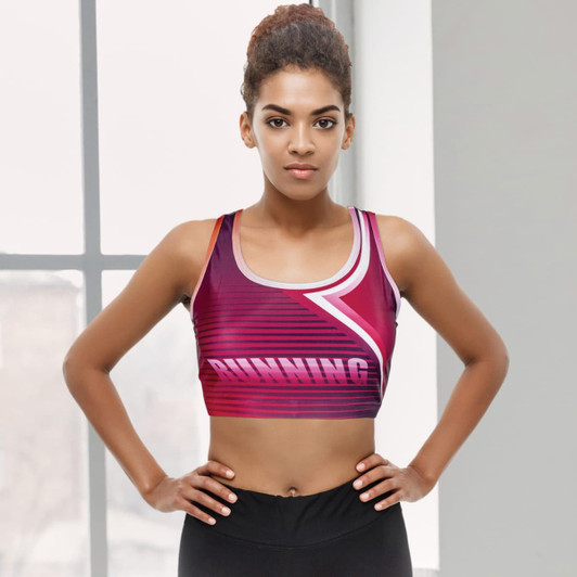 A women's athletic crop top in shades of pink and purple with a logo, featuring a sporty design.