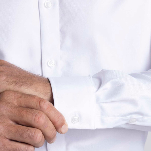 A men's white button-up shirt with a close-up of the cuff and buttons, featuring a logo.