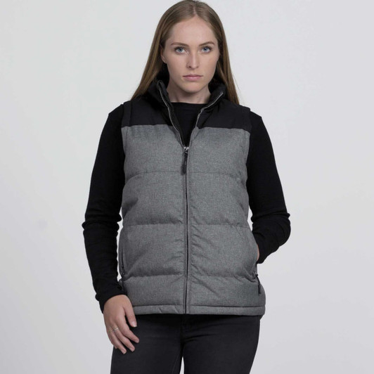 A woman models a grey and black smpli Axle Puffa Vest featuring a zip front and padded design.
