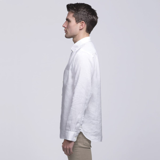 A white linen button-up shirt displayed on a model from the side, featuring a pocket and a logo.