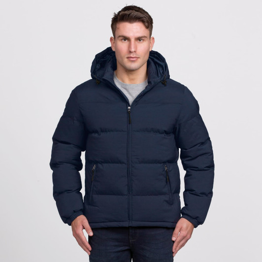 A navy puffer jacket with a hood and zip-up front, featuring side pockets. The model is wearing it with a grey top.