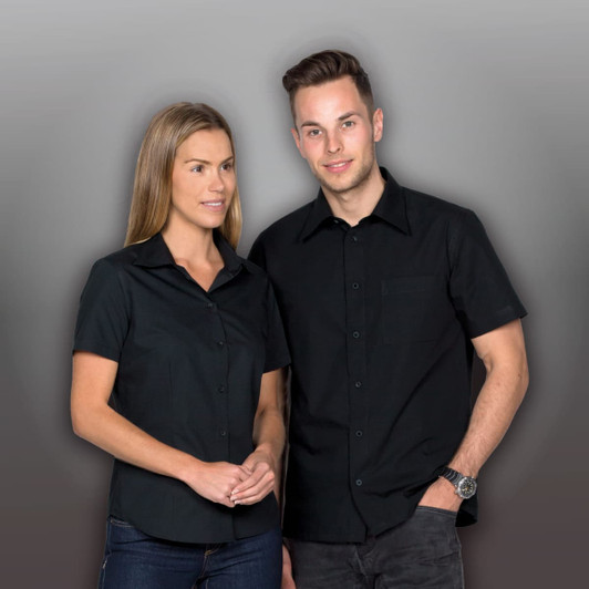 A black short sleeve button-up shirt displayed on a male and female model, featuring a pocket and logo.