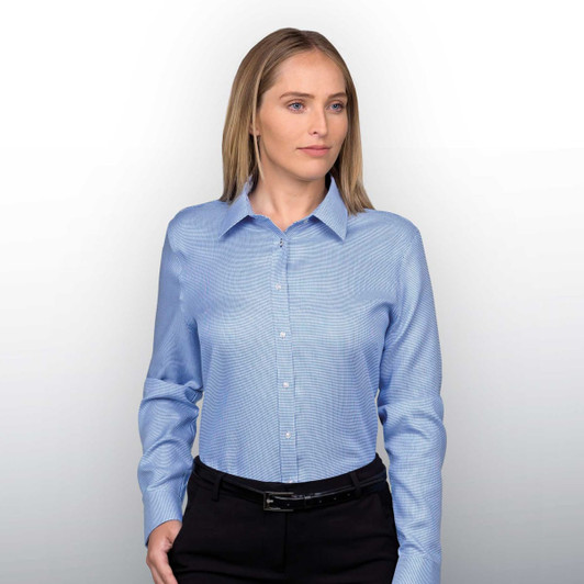 A light blue button-up shirt for women, featuring a collar and a logo, modelled by a woman.