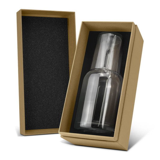 A glass carafe and tumbler set in a brown box with black interior padding. The glass is clear and sleek.