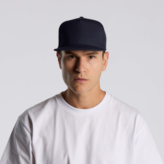 A navy trucker cap featuring a mesh back and a solid front, worn by a person in a white t-shirt.
